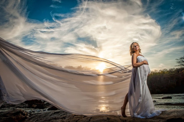 Woman near river in long flowy white dress