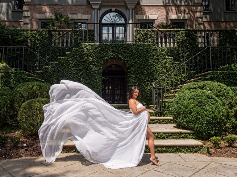 Woman in long white flowy dress outside building