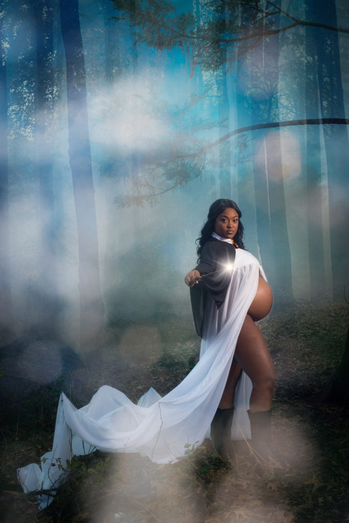 pregnant girl posing with stomach showing in Harry Potter themed woods