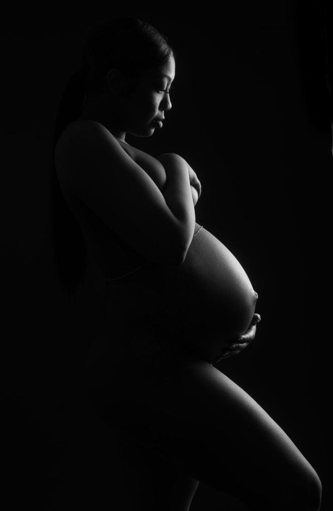 Pregnant woman in dramatic studio lighting