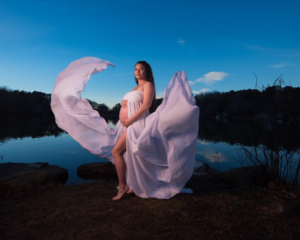 Woman near lake in white flowy dress